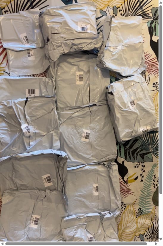 Bed covered with grey Pikobuy courier parcels from an arrived haul — Pikobuysheet buyer share